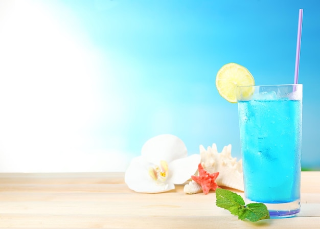 Cocktail refrescante na mesa de madeira sobre fundo azul