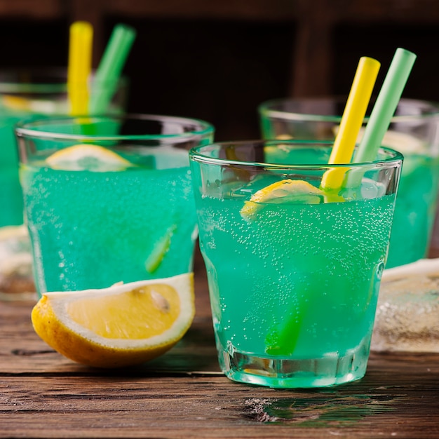 Cocktail verde com limão e gelo na mesa de madeira