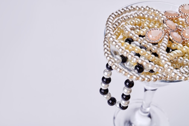 Cocktailglas mit Schmuck und Perlen und Kopienraum