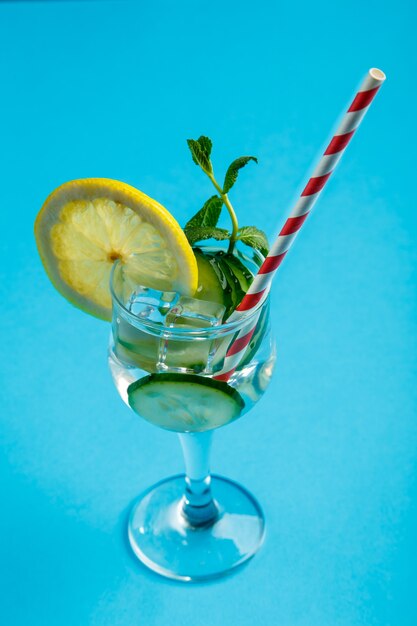 Cocktailgurkenwasser mit Zitrone und Minze in einem Glas auf einer Serviette auf einer blauen Oberfläche