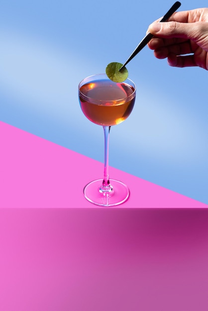 Cocktailminimalismuscocktail auf einem farbigen hintergrundcocktail in der hand