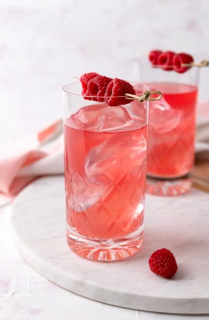 Cocktails de rosa rosa com framboesa em copo de cristal na mesa