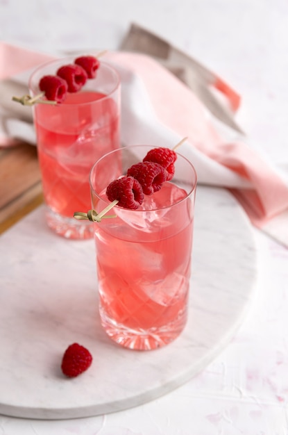 Cocktails de rosa rosa com framboesa em copo de cristal na mesa
