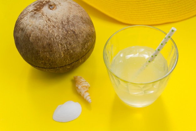 Foto coco y agua de coco en vaso con paja