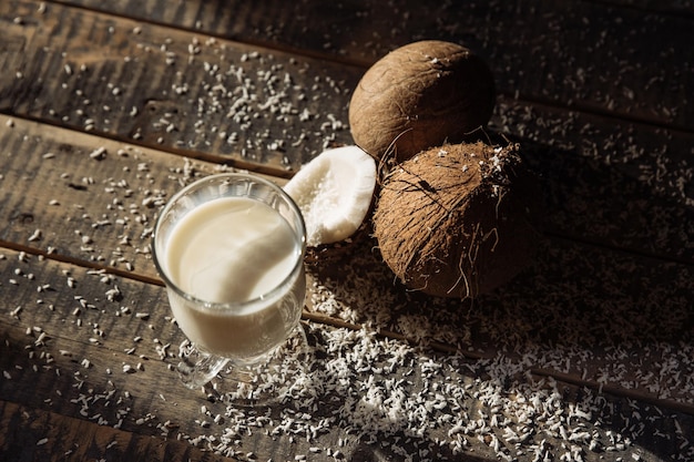 Coco e leite coco quebrado em fundo de tábuas de madeira