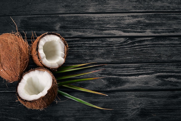 Coco em um fundo de madeira Frutas tropicais e nozes Vista superior Espaço livre para texto