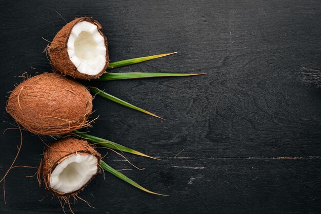 Coco em um fundo de madeira frutas tropicais e nozes vista superior espaço livre para texto