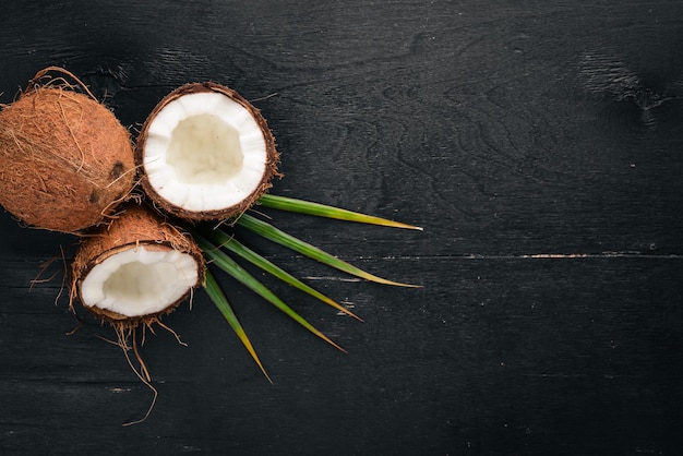 Coco em um fundo de madeira Frutas tropicais e nozes Vista superior Espaço livre para texto