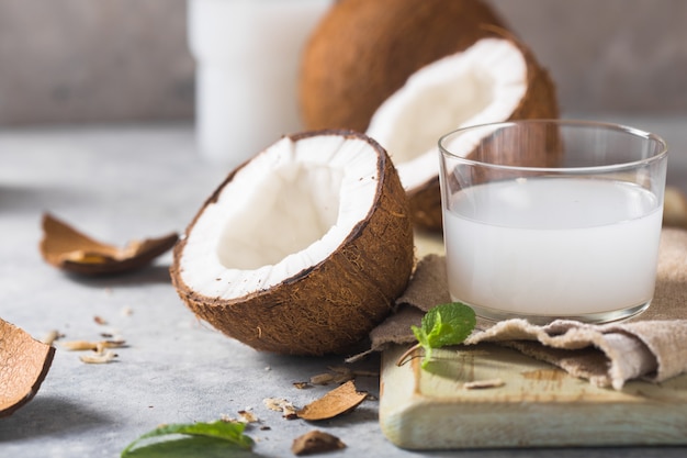 Coco fresco agrietado, leche y nuez rebanada sobre fondo de hormigón, espacio para texto Ingredientes alimentarios, estilo de vida saludable, paraíso