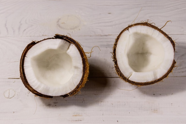 Coco fresco maduro na mesa de madeira branca Vista superior
