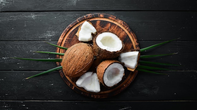 Coco fresco sobre fondo negro Frutas tropicales Tuerca Vista superior Espacio libre para el texto