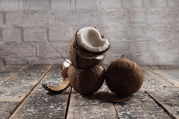 Foto coco y leche coco coco roto sobre fondo de tablas de madera