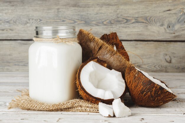 Coco y leche de coco en la mesa de madera rústica