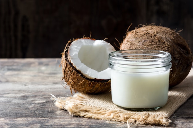 Coco y leche de coco en mesa de madera