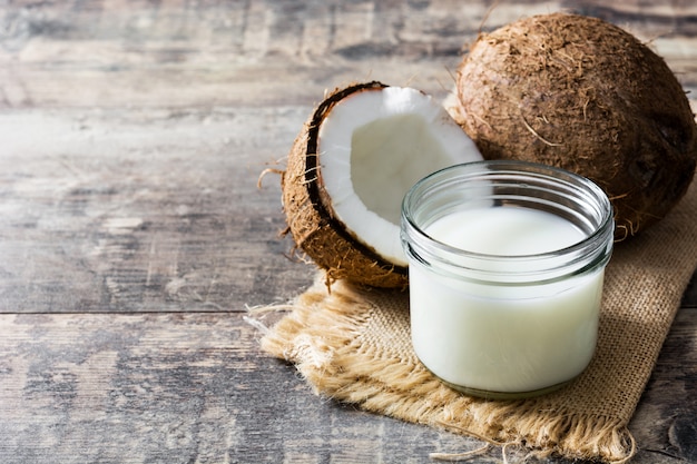 Coco y leche de coco en mesa de madera