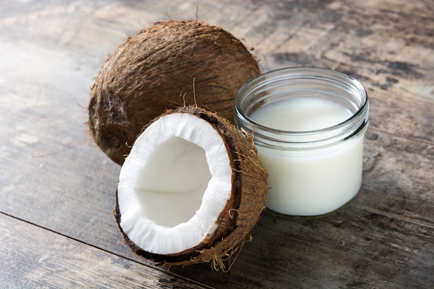 Coco y leche de coco en mesa de madera