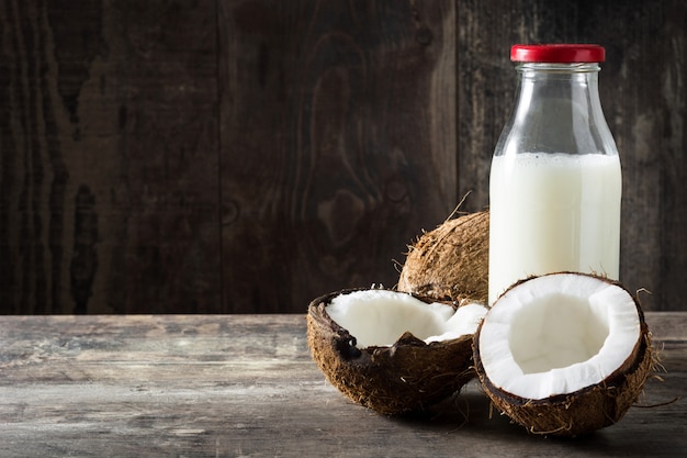 Coco y leche de coco en mesa de madera