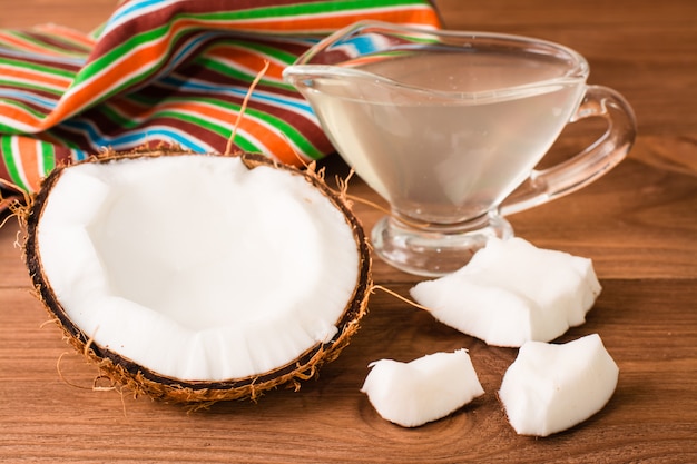 Coco picado y leche de coco en un recipiente sobre una mesa de madera