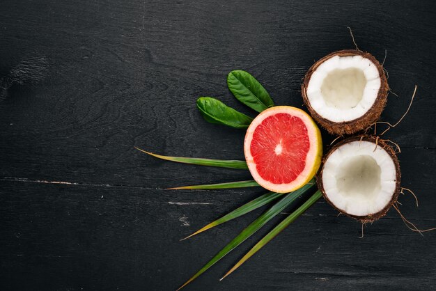 Coco y pomelo Frutas frescas Sobre un fondo de madera Vista superior Espacio libre para texto