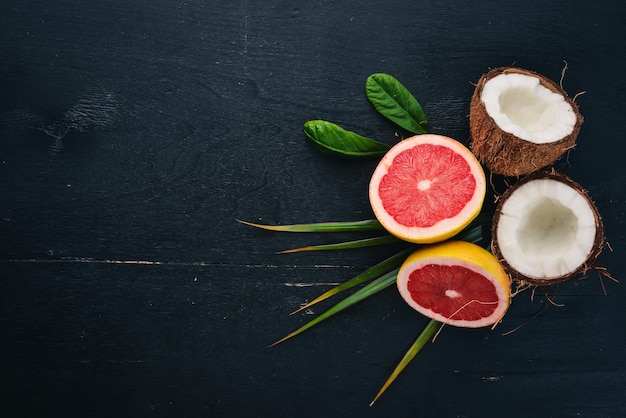 Coco y pomelo. Frutas frescas. Sobre un fondo de madera. Vista superior. Espacio libre para texto.