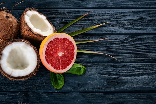 Coco y pomelo Frutas frescas Sobre un fondo de madera Vista superior Espacio libre para texto