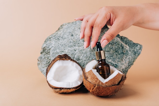 Coco y un tubo de cosméticos sobre un fondo de piedra