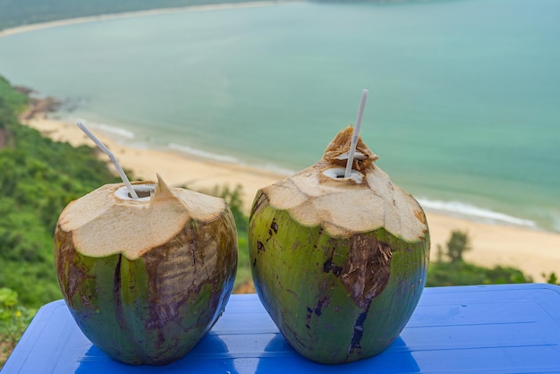 Foto cocos tropicais na mesa à beira-mar