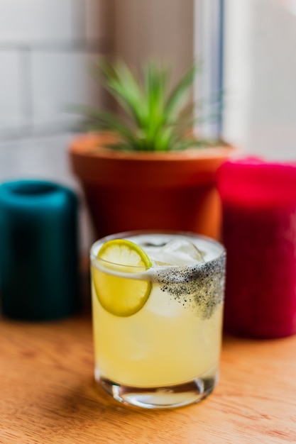 cóctel agrio helado en vaso de rocas con rueda de limón