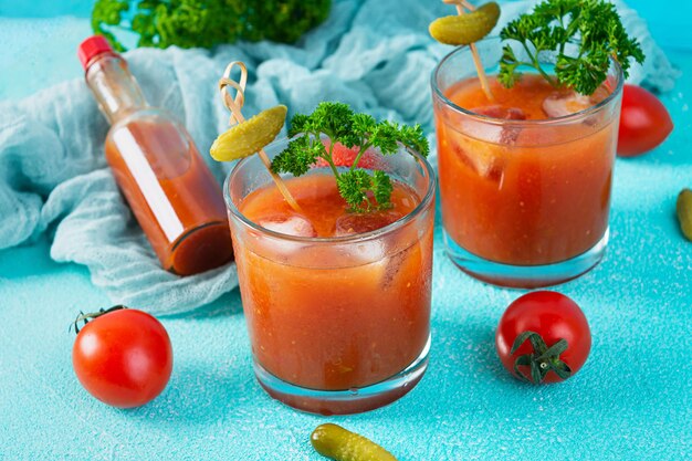 Cóctel de alcohol Bloody Mary sobre fondo azul. Cóctel clásico con jugo de tomate y vodka.