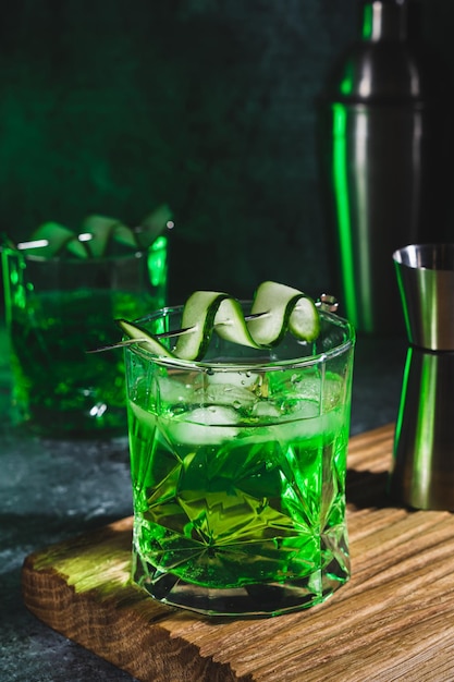 Cóctel de alcohol con pepino en vaso de whisky con cubitos de hielo Bebida espirituosa de verano y agitador