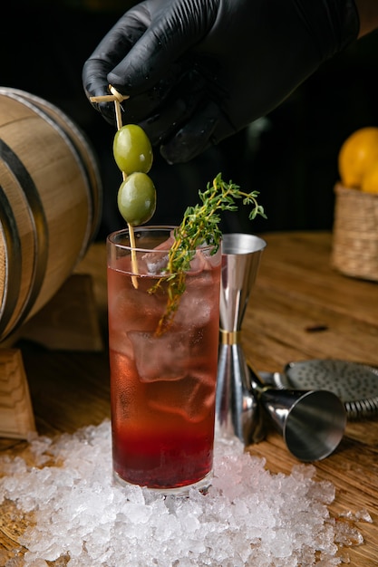 Cóctel alcohólico con hielo y aceitunas