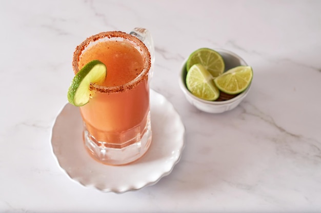 Cóctel alcohólico mexicano Michelada con cerveza, jugo de lima, jugo de tomate