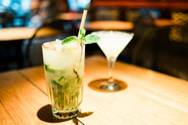 Cóctel alcohólico de mojito con rebanadas de lima de menta y hielo en una barra Imagen de enfoque selectivo