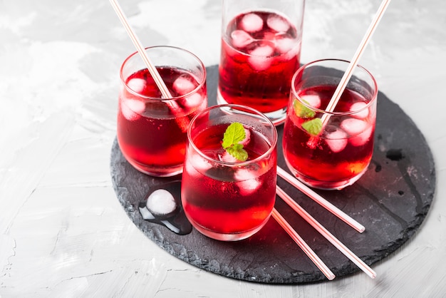 Cóctel alcohólico rojo con hielo y menta