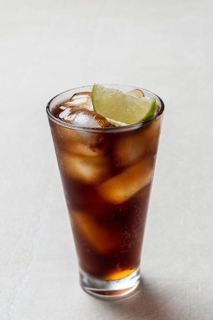 Foto cóctel alcohólico de ron con hielo y lima, cuba libre o té helado long island