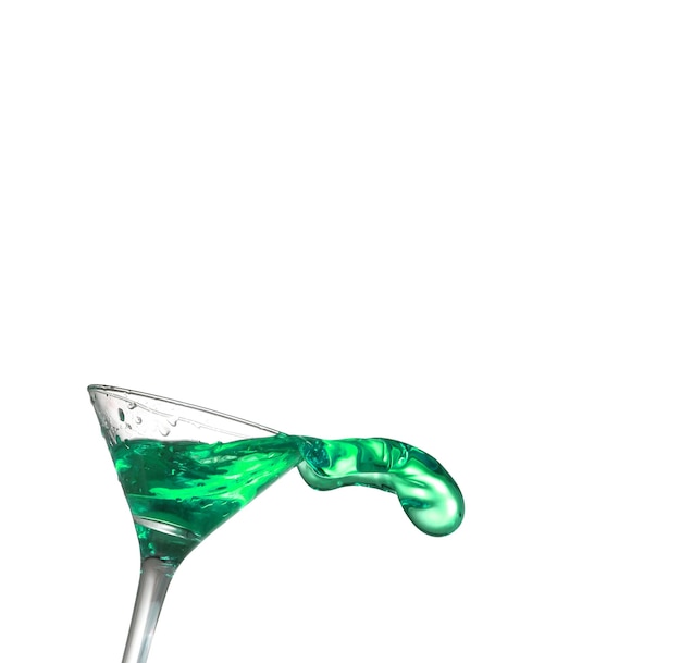 Cóctel alcohólico verde sobre salpicaduras de aislamiento blanco