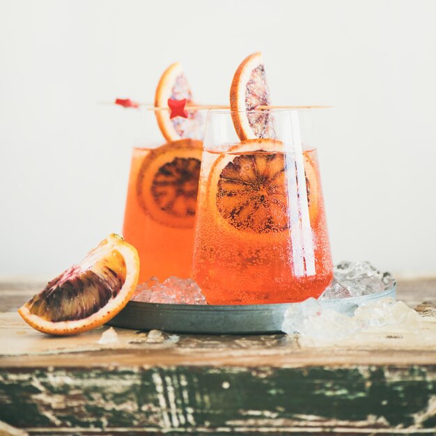 Cóctel Aperol Spritz con cultivo cuadrado de naranja y hielo