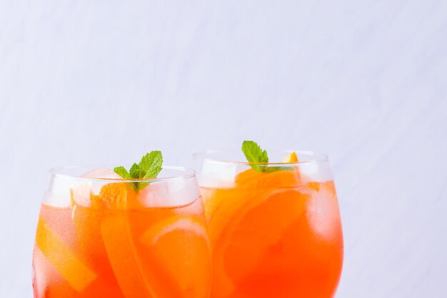 Cóctel Aperol Spritz con hojas de menta sobre fondo blanco cóctel italiano Aperol Spritz