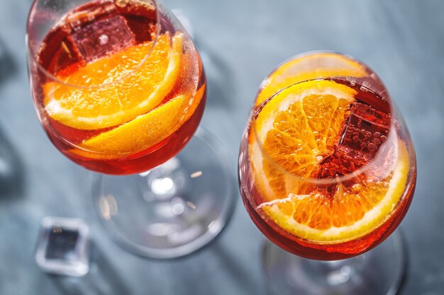 Cóctel de Aperol Spritz con rodajas de naranja servido en vasos. De cerca