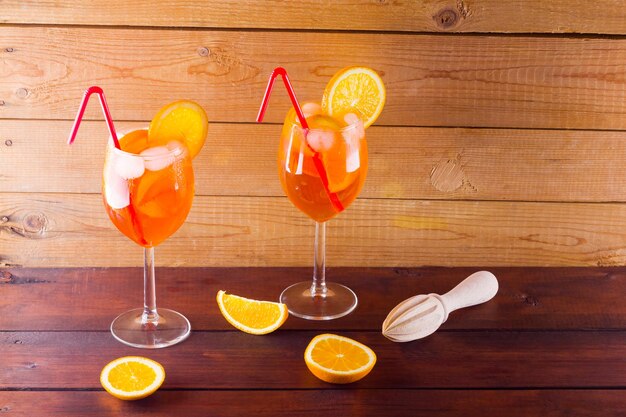 Cóctel de Aperol Spritz en tablas de madera Dos vasos de cóctel de Aprol Spritz con rebanadas de naranja