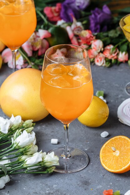 Cóctel de aperol spritz en un vaso grande de verano bebida fría italiana baja en alcohol sobre un fondo decorativo ...