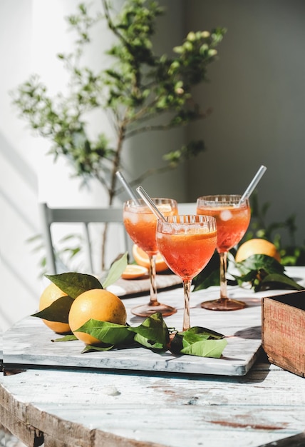 Cóctel Aperol Spritz en vasos con naranjas en la mesa