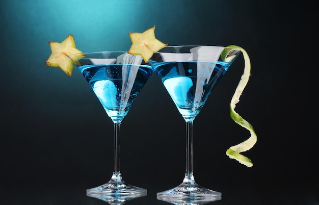 Cóctel azul en copas de martini sobre fondo azul.