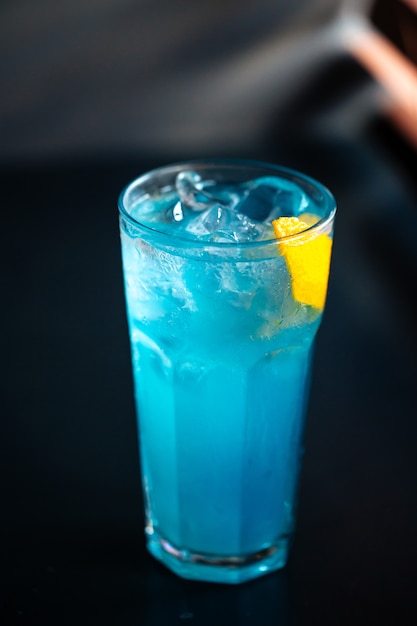 Cóctel azul highball con hielo y piel de naranja