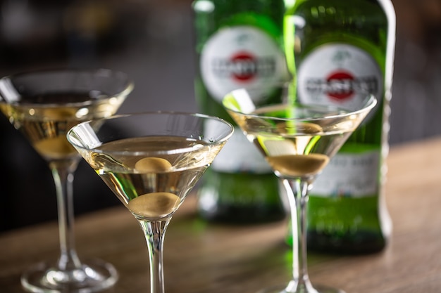 Cóctel de bebida corta Dry Martini con ginebra, vermú seco y guarnición de aceitunas.