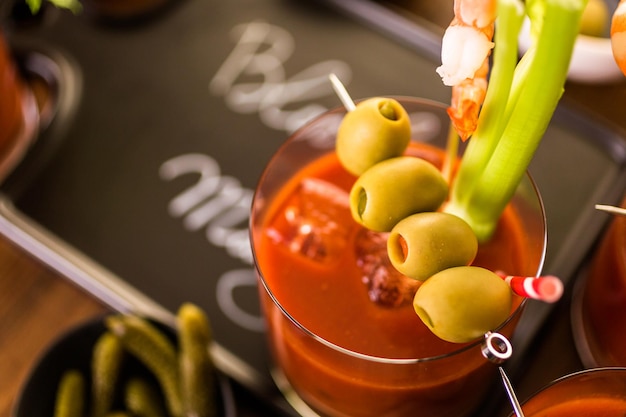 Cóctel Bloody Mary aderezado con aceitunas, encurtidos y camarones cóctel.