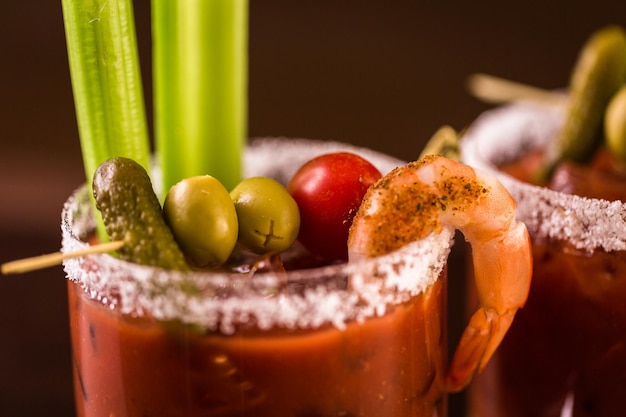 Cóctel Bloody Mary adornado con apio y aceitunas.