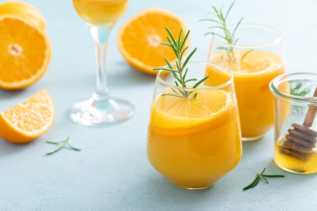 Cóctel de bourbon de miel refrescante de verano con romero y jugo de naranja