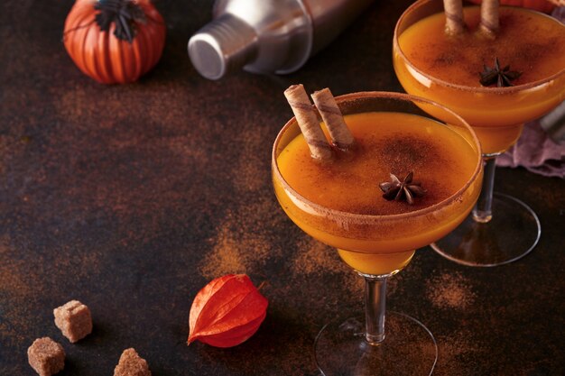 Cóctel de calabaza con canela, jugo de naranja y cacao en tazas de vidrio. Bebida de otoño de calabaza para Halloween o Acción de Gracias.