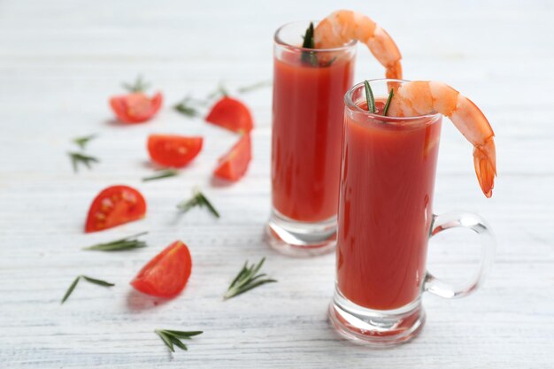 Cóctel de camarones con salsa de tomate sobre mesa de madera blanca